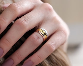 May include: Three gold rings with a black bear silhouette and the words "mountain mama" engraved on the top ring.