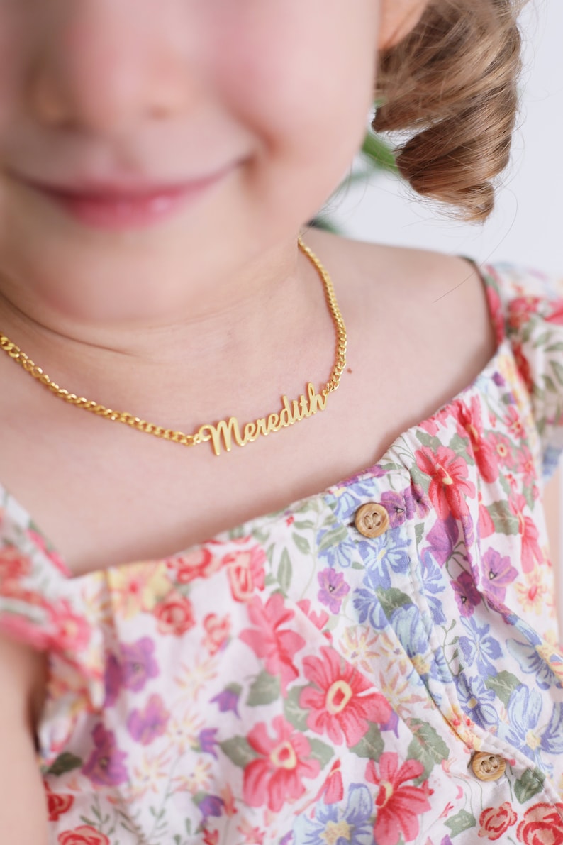 Pu&ograve; includere: Una collana a catena d'oro con il nome "Meredith" scritto in corsivo.