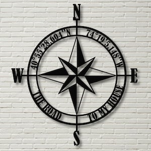 May include: Black metal compass with a star design and the text "The Road To My House" and coordinates 40°55'28.604'N 74°19'51.148'W.