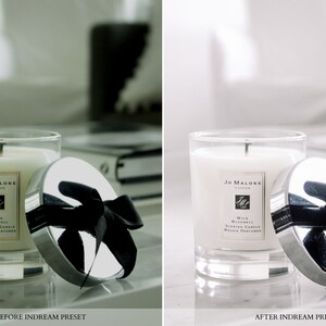 May include: A white Jo Malone London Wild Bluebell Scented Candle in a glass jar with a silver lid and a black ribbon. The candle is on a white surface.