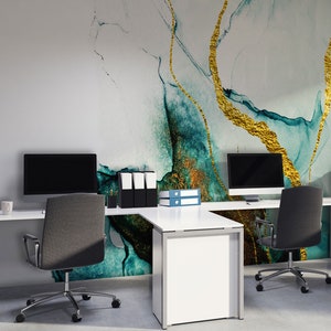 Peut inclure: Un espace de travail moderne avec deux bureaux blancs et des chaises de bureau noires. Le mur derri&egrave;re les bureaux pr&eacute;sente un papier peint abstrait bleu sarcelle et or.