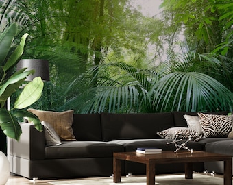May include: A dark gray sectional sofa with pillows in a living room setting. The wall behind the sofa features a photo mural of a lush green tropical jungle with palm trees and ferns.