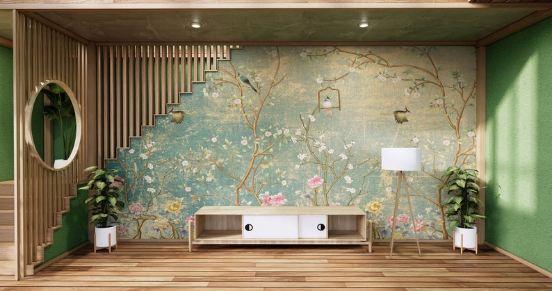 May include: A wooden TV stand with two drawers and a floral wallpaper with birds behind it. The stand is in a room with a wooden floor and green walls.