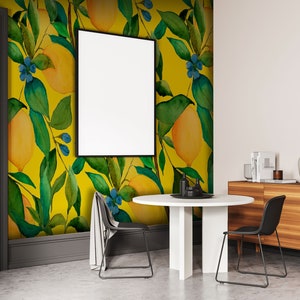 Puede incluir: Un comedor con papel tapiz amarillo y verde con motivos de limones, una mesa redonda blanca con dos sillas negras y un aparador de madera con libros y objetos decorativos.