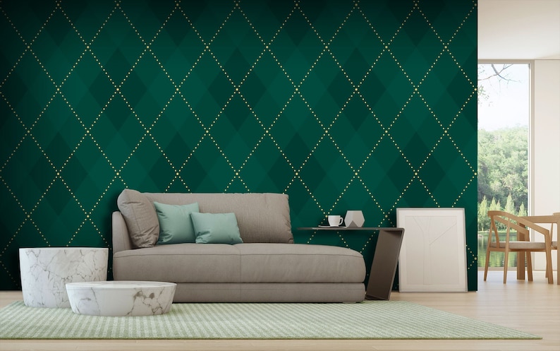 Op de afbeelding: Een woonkamer interieur met een groene en gouden behang met patroon, een beige bank met kussens, een witte marmeren salontafel en een wit frame aan de muur.
