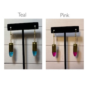 May include: Two pairs of bullet casing earrings, one pair with teal coloured resin and the other with pink coloured resin.