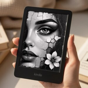 May include: A black Kindle e-reader displaying a black and white image of a woman's face with cracked textures and a white flower. The word "kindle" is printed at the bottom of the device.
