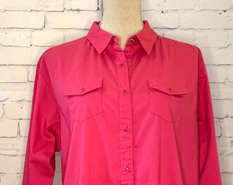 May include: A long-sleeved button-down shirt in a vibrant hot pink color. The shirt features a classic collar, a full-length front button placket, and two chest pockets with buttoned flaps. The cuffs also include buttons for a secure fit.