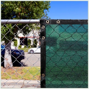 May include: Green construction mesh privacy fence with black edging and metal grommets. The fence is attached to a chain link fence.