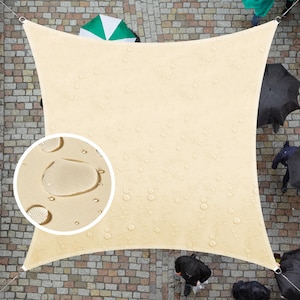 May include: A beige square shade sail with water droplets on the surface. The sail is suspended from four corners with metal rings. The sail is hanging over a brick patio.