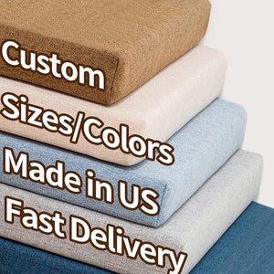 May include: Stack of five different colored fabric cushions with the text "Custom Sizes/Colors Made in US Fast Delivery" on the front.