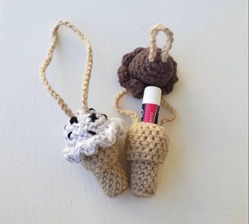 Peut inclure: Deux porte-baume &agrave; l&egrave;vres en forme de cornet de cr&egrave;me glac&eacute;e en crochet. L'un est brun et l'autre est blanc avec des points noirs. Les deux ont un c&ocirc;ne en crochet beige et une boucle pour accrocher.