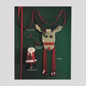 May include: A collection of five Christmas ornaments made with macrame. The ornaments include a reindeer, a holly sprig, a green wreath, and two Santa Claus bell ornaments. The ornaments are displayed against a green background.
