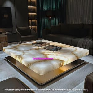 May include: A contemporary square coffee table with a marble-effect top with gold veining. The table has a gold-coloured base and a dark metal support. The room features dark furniture and a green curtain.