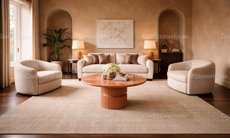 May include: A stylish living room with a beige sofa, armchairs, and a round coffee table. The room is decorated in neutral tones, with a large rug, lamps, and a plant. The text "CraftStoneHouse" is visible.