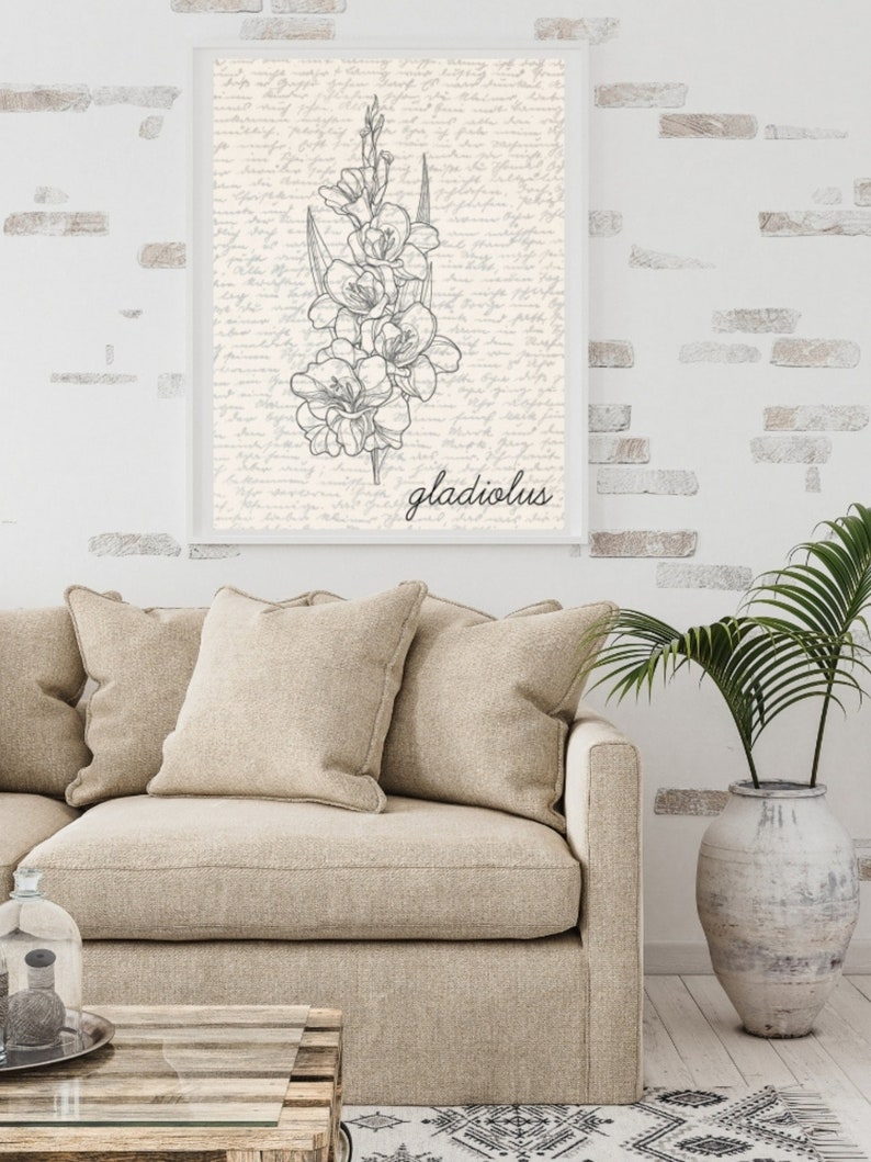 May include: A black and white line drawing of a gladiolus flower on a cream background with a handwritten script pattern. The word "gladiolus" is written in black below the flower.
