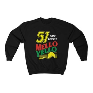 Puede incluir: Sudadera negra con un diseño gráfico amarillo, rojo y verde. El gráfico presenta el número 51, las palabras "Cole Trickle" y las palabras "Mello Yello".