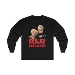 May include: Black long-sleeve t-shirt with a graphic of two puppets, one with a mustache and the other with a goatee. The text "OLD SURE BEATS DEAD!" is printed in red below the puppets.