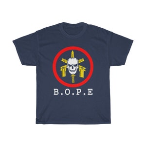Puede incluir: Camiseta azul marino con un dise&ntilde;o gr&aacute;fico. El dise&ntilde;o incluye una calavera, pistolas y una espada dentro de un c&iacute;rculo rojo. El texto blanco "B.O.P.E" est&aacute; impreso debajo.
