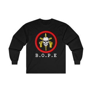May include: Black long-sleeve shirt featuring a circular emblem with a skull, guns, and a knife, surrounded by a red ring. The text "B.O.P.E" is printed below the emblem in white.