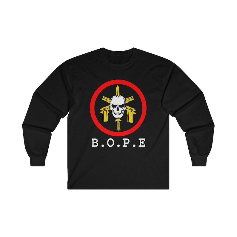 May include: Black long-sleeve shirt featuring a circular emblem with a skull, guns, and a knife, surrounded by a red ring. The text "B.O.P.E" is printed below the emblem in white.
