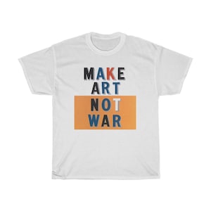 以下が含まれることがあります： オレンジ色の背景にカラフルなブロック体で「MAKE ART NOT WAR」と書かれた白いTシャツです。