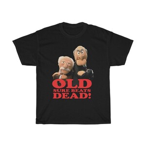 Peut inclure: T-shirt noir avec un graphique de deux hommes âgés avec le texte "OLD SURE BEATS DEAD!" en rouge.