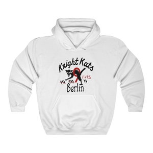 May include: White hooded sweatshirt with a black and red graphic of a cat with the text "Knight Kats 9 Lives Berlin".