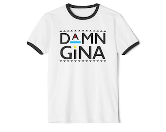 May include: White t-shirt with black trim around the collar and sleeves. The shirt features the text "DAMN GINA" in bold black letters, with a blue line above the "N" and a yellow dot above the "i".