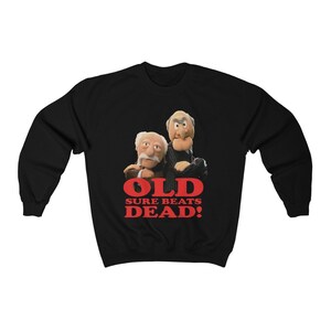 May include: Black sweatshirt with a graphic of two puppets, one with a mustache and the other with a beard, and the text "OLD SURE BEATS DEAD!"