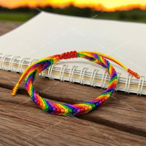May include: A rainbow colored friendship bracelet made of braided string. The bracelet is tied with a knot at the end.