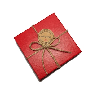 May include: A red gift box tied with twine and a brown paper tag that says "Thank you" with a heart.