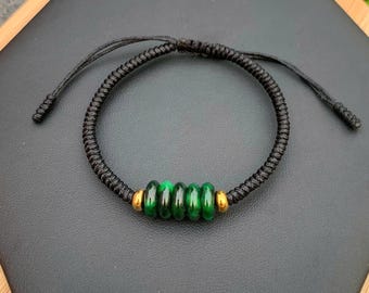 Puede incluir: Una pulsera de cordón trenzado negro con cinco cuentas verdes y dos cuentas doradas. La pulsera es ajustable con nudos corredizos. Las cuentas son de color verde vibrante.