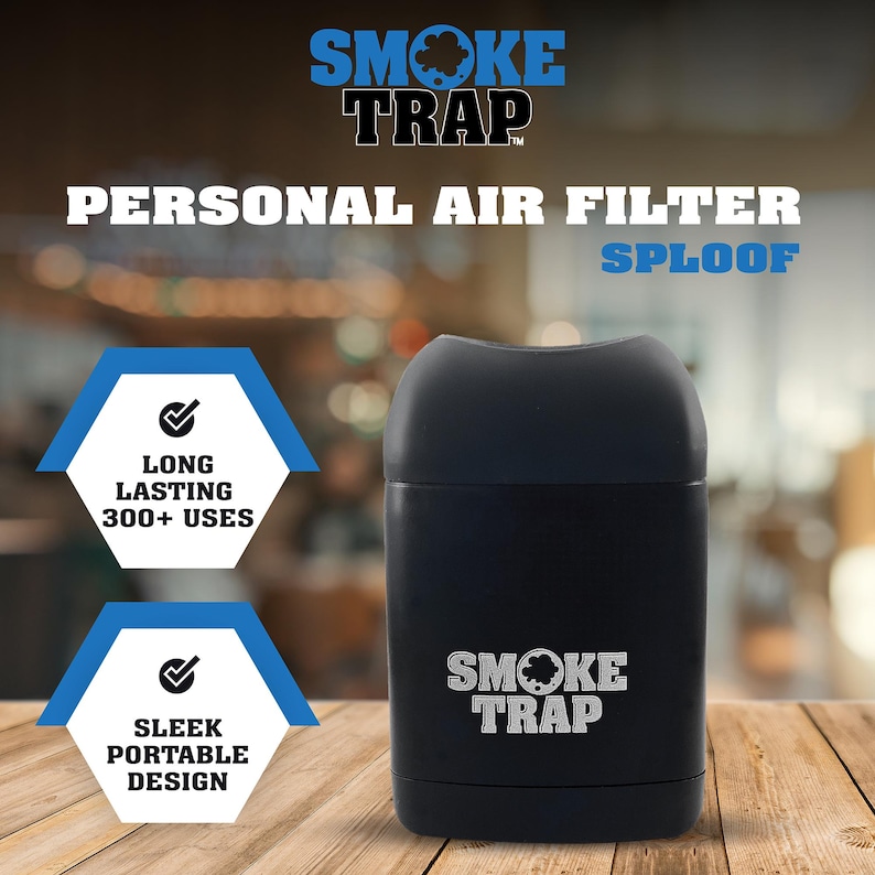 May include: A black, cylindrical air filter with the text "SMOKE TRAP" printed on it. The air filter is on a wooden surface. The text "PERSONAL AIR FILTER" and "SPLOOF" are printed above the air filter. Two blue hexagonal icons with checkmarks are on the left side of the image. The top icon says "LONG LASTING 300+ USES" and the bottom icon says "SLEEK PORTABLE DESIGN".