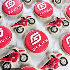 Pu&ograve; includere: Una collezione di biscotti di zucchero decorati in rosso e bianco con il logo GasGas e un design di una moto da cross.