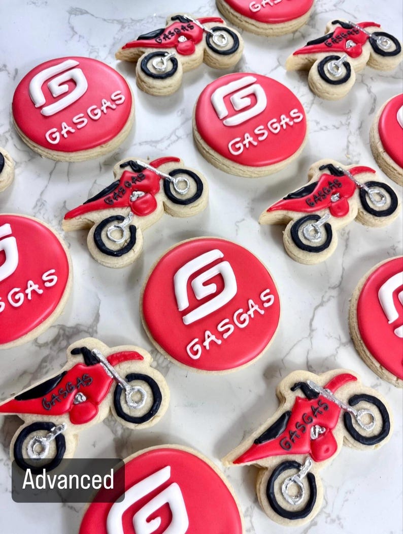 Pu&ograve; includere: Una collezione di biscotti di zucchero decorati in rosso e bianco con il logo GasGas e un design di una moto da cross.