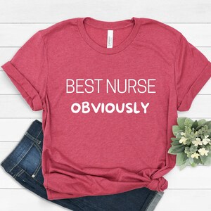 May include: A red t-shirt with the text "BEST NURSE OBVIOUSLY" in white.