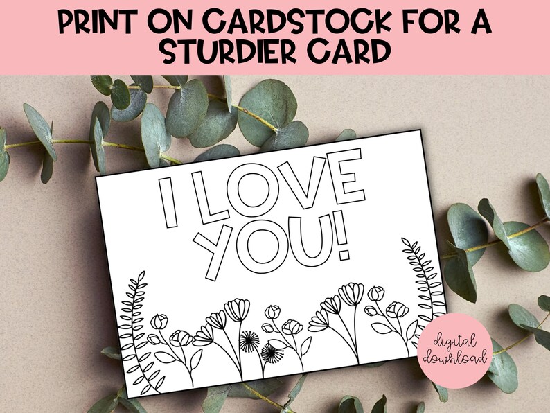 May include: Printable coloring page featuring the words "I love you!" in bold, outlined letters. The design includes a border of simple flowers and leaves.