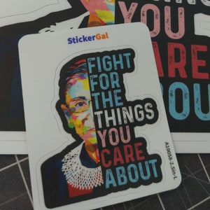 May include: Two die-cut stickers featuring a colorful pop-art portrait of Ruth Bader Ginsburg on the left and the text FIGHT FOR THE THINGS YOU CARE ABOUT on the right. The stickers include the brand name StickerGal and a product code A10058-2.5in-L.