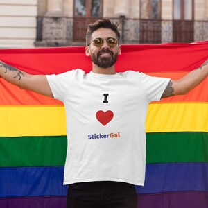 May include: White t-shirt with the text "I ❤️ StickerGal" and a red heart. The person is holding a rainbow flag. The flag has horizontal stripes of red, orange, yellow, green, blue, and purple. The person is wearing sunglasses.