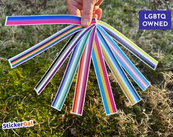May include: A fan-shaped collection of ten long, thin rectangular stickers, each featuring different horizontal color stripes representing various pride flags. A blue square in the corner contains the white text LGBTQ OWNED, and the logo StickerGal is visible.