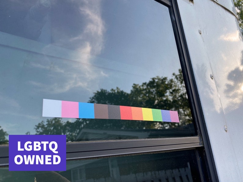 May include: A window with a colorful stripe of various colors, including pink, blue, and rainbow hues. The text "LGBTQ OWNED" is displayed on a purple background in the lower left corner.