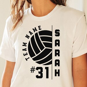 May include: White t-shirt with a black volleyball graphic, the text "TEAM NAME" and "SARAH" and the number "#31"
