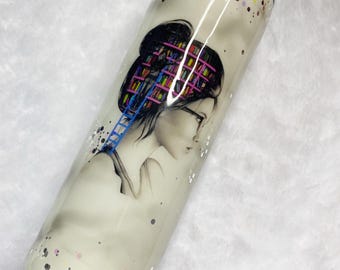 May include: A white tumbler with a watercolor illustration of a woman with a library inside her head. The design includes a blue ladder and colorful books. The tumbler is decorated with glitter and a black lid.