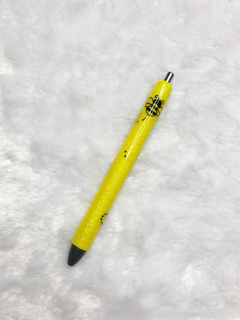 May include: A yellow glitter pen with a black bee design.