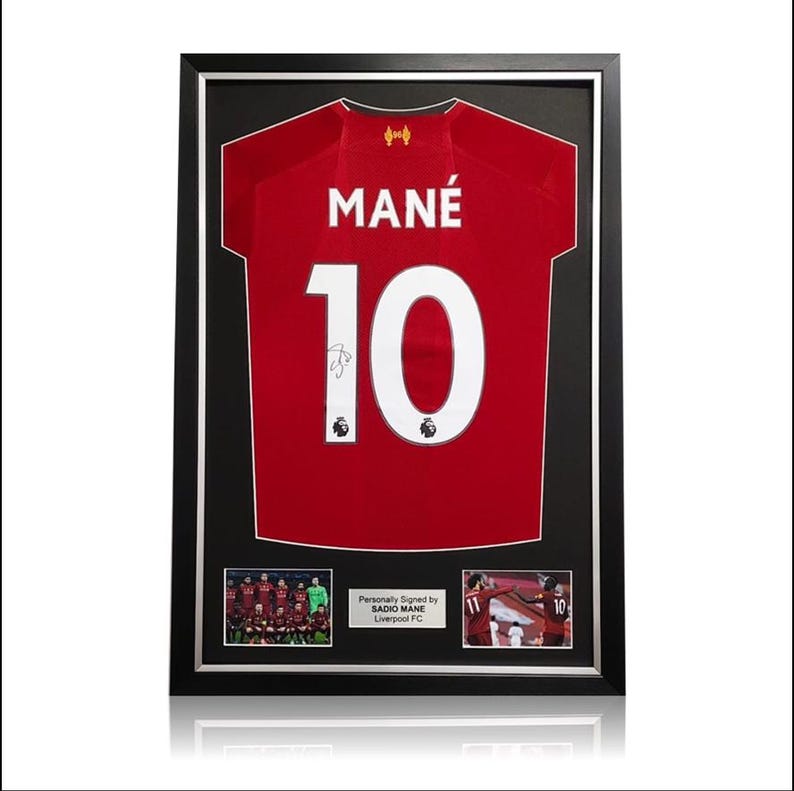 May include: Framed red football shirt with the name "MAN&Eacute;" and number "10" on the back. The shirt is signed by Sadio Man&eacute;, a player for Liverpool FC.