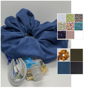 May include: A blue corduroy scrunchie with a zipper pocket. The pocket contains a phone charger, cash, and a small bottle of hand sanitiser.