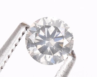 May include: A clear round diamond gemstone held in a pair of silver tweezers.