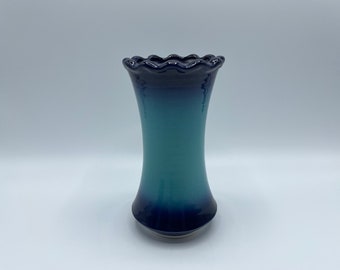 May include: A blue and green ceramic vase with a scalloped rim. The vase is glazed in a gradient of blue and green.