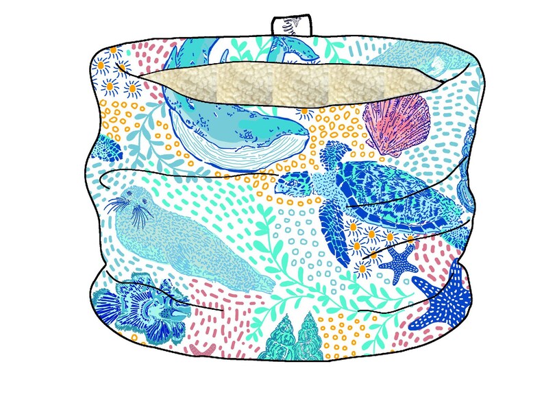 K&ouml;nnte beinhalten: Eine wei&szlig;e Stoffr&ouml;hre mit einem blauen, gr&uuml;nen und rosa Meereslebewesen-Muster. Das Muster enth&auml;lt einen Wal, eine Schildkr&ouml;te, eine Robbe und Korallen.